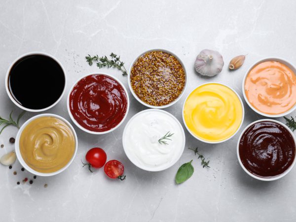 Vielfalt an Dips in Schalen: Ketchup, Senf, BBQ, Joghurt und mehr, um Gerichte zu verfeinern.